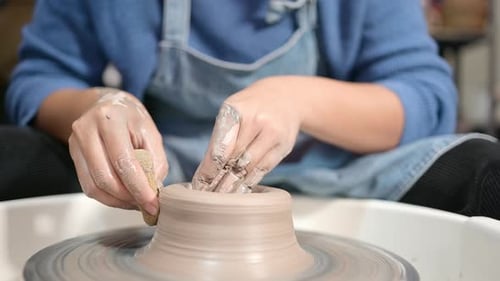 Pottery artist, Young female making a piece of clay molding calmly and meticulously In order to prod