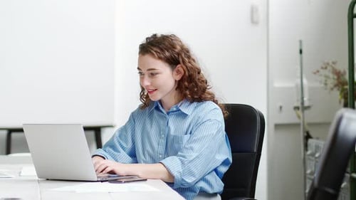 Young Woman Working at Computer in Bright Office