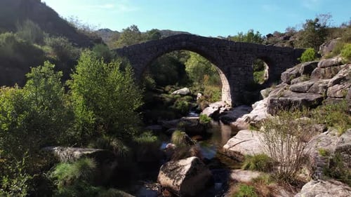 Flug über eine alte Steinbrücke über einen schönen Fluss. Erstaunliche Naturlandschaft