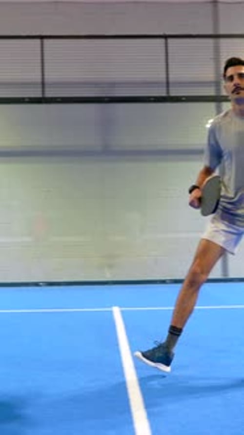 Two male pickleball players competing on a blue court