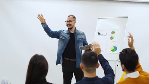 Businessman Coach Trainer Presents Report Shows Diagrams on Flip Chart in Conference Hall Audience