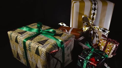 Colorful Christmas Gift Boxes With Ribbons on Black Studio Background