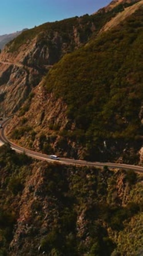 Big Sur Morro Bay rocks towering over the ocean waters. Highway in mountains by the Pacific Ocean