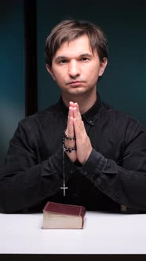 Adult Male Prays with Hands Clasped Together