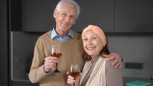 Smiling Senior Couple with Wine Glasses Indoors