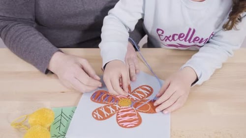 Little Girl Learning How to Sew with Her Mother at the Craft Table