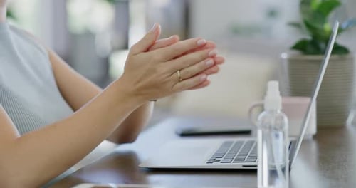 Woman Applying Hand Sanitizer Before Using Laptop
