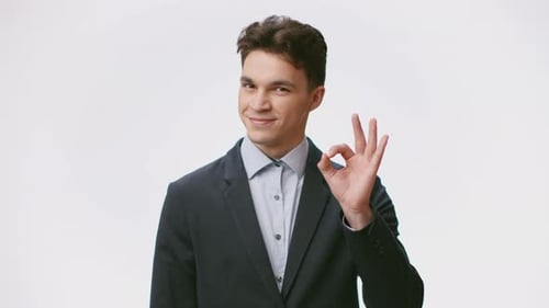 Young Man in Blazer Gives OK Hand Sign