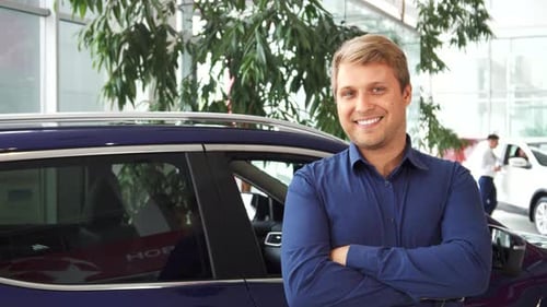 Smiling Man Holding Keys in Car Dealership