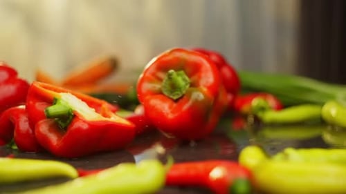 Ripe Red Pepper Rolls Into a Beautiful Background of Fresh Vegetables