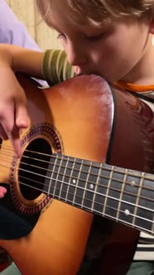 Guitar Lesson with a Child Indoors