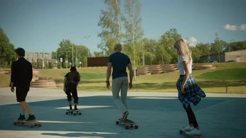 Four Cool Young Girls and Guys Riding Longboard and Skateboard Through Stylish Hipster Part of the