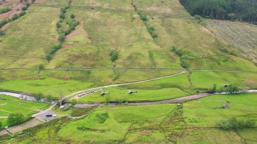 Aerial View of Fleet of Helicopters Landing in Lush Green Glen in Mountains, Scottish Highlands, Sco