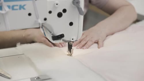 CloseUp of Sewing Machine in Action with Hands on Fabric Showcasing Precision and Craftsmanship