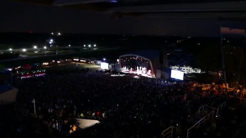 Concerto movimentado, muitos efeitos de luzes agradáveis na multidão. Sem som. Grande palco ao ar livre. Festival de música com
