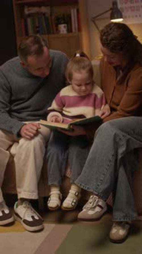 Family Reading a Storybook Together at Home Indoors