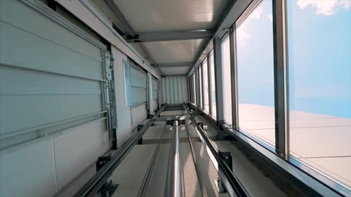 Elevator lift cabin moves up inside illuminated elevator shaft with hydraulics with many floors slow