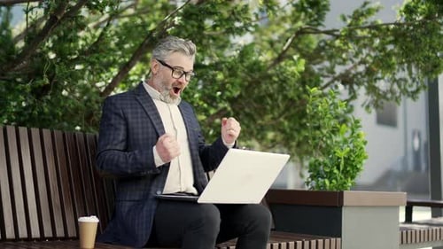 Adult Man Works on Laptop, Cheers Success