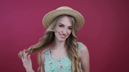 Smiling Woman Wearing Straw Hat in Studio Setting