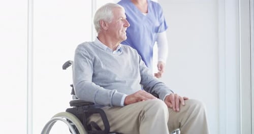 Smiling Senior Man in Wheelchair with Medical Professional