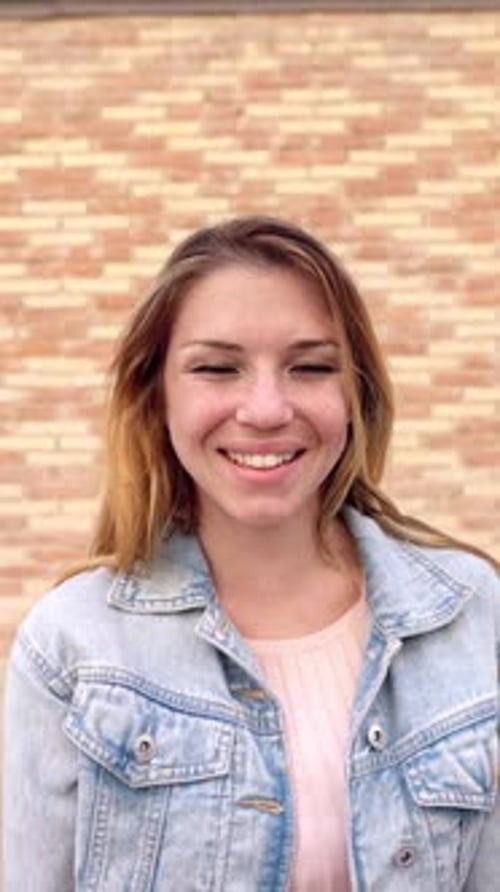 Smiling Woman in Denim Jacket in Urban Setting