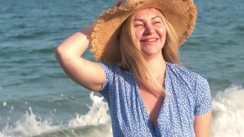 Smiling Woman in Blue Dress on Sunny Beach