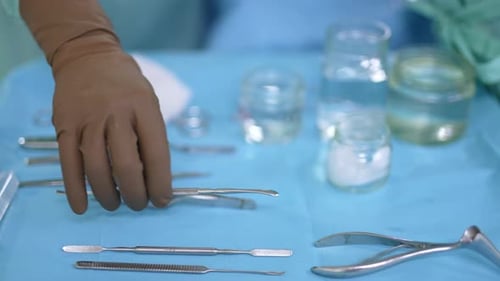 Metal tools for conducting surgical operation and glass jars at the table.