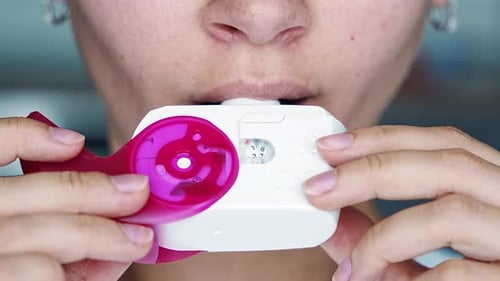 Close Up View of Woman Using Medicine Dry Powder Inhaler for Treatment Asthma or COPD Diseases