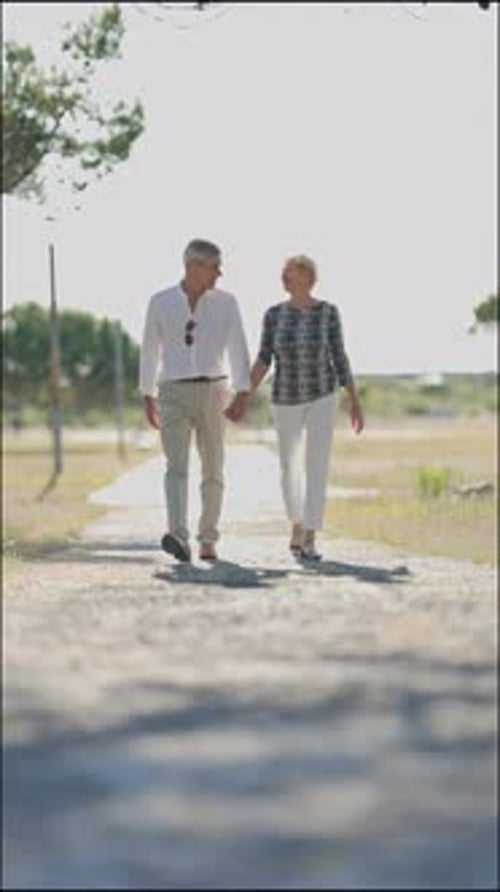 Happy Senior Couple Walking on Country Road
