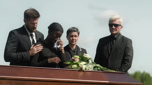 Mourners Gather Around Casket During Funeral Service