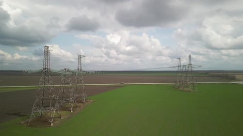 Aerial View of Power Lines Over Green Agricultural Field