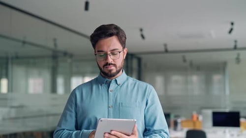 Smiling Young Business Man Manager with Tab Standing in Office Portrait