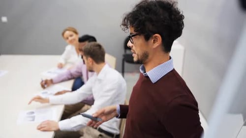 Teamwork, Corporate And People Concept - Business Team With Flipboard At Presentation In Office