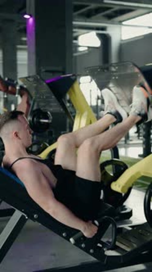 Muscular Man Performing Leg Press Workout at the Gym