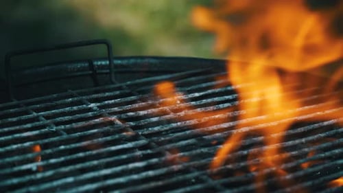 Nahaufnahme eines Grills mit tanzenden heißen Feuerflammen.