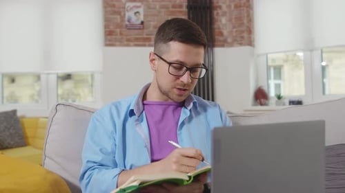 Man Working From Home Taking Notes
