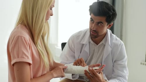 Woman with Arm Cast Doctor Examines Her