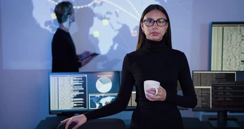 Confident Female Cybersecurity Analyst or Manager in Large Cyber Security Operations Center SOC