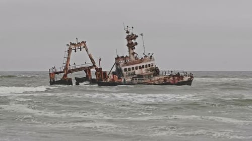 El naufragio de Zeila en las grises olas del océano a lo largo de la costa de los esqueletos de Namibia, Wide Shot