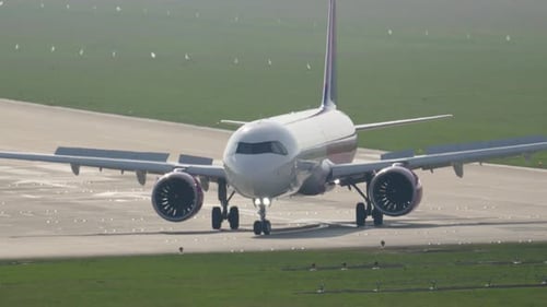 Airplanes taxiing on the runway at the busy airport during daylight hours