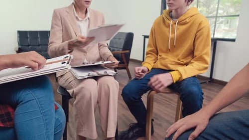 Psychothérapeute remettant aux adolescents un questionnaire à remplir lors d'une séance de groupe
