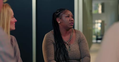Woman expressing herself during group therapy session, seated in healing circle