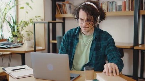 Young Guy College Student Sit at Desk Use Pc Laptop Computer Watching Distance Online Learning