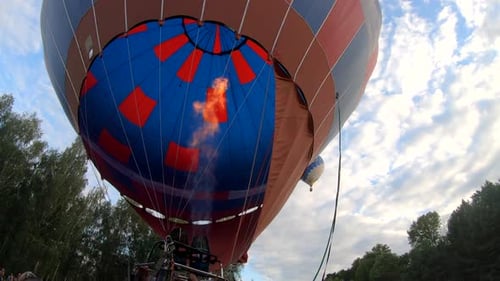 Hot Air Balloon Inflating with Flames on Sunny Day