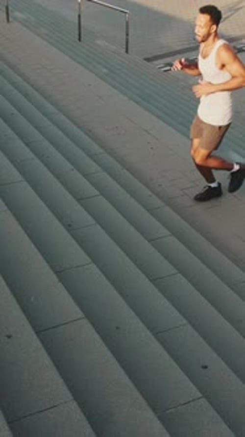 Man Running Up Concrete City Stairs