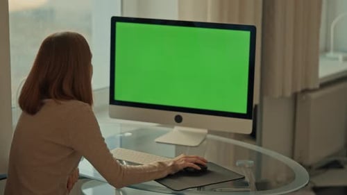 Woman Working at Computer with Chroma Key Screen