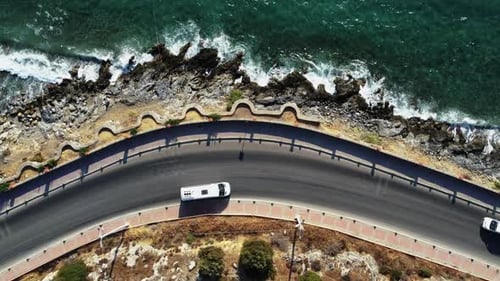 Aerial top view: cars driving near the coast, scenic landscape, vehicle traveling along a seashore r