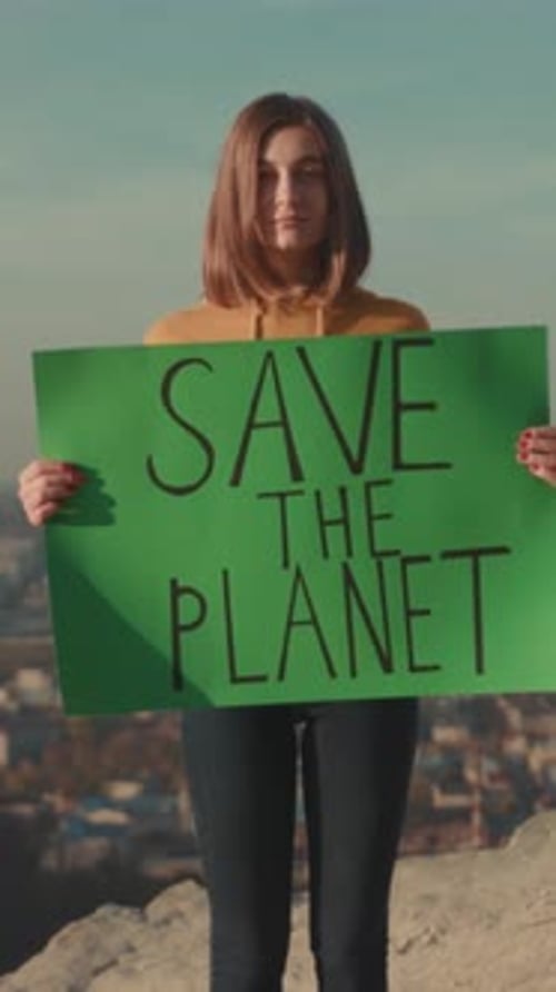 Peaceful Protester Standing Above Cityscape Woman in Hoodie Displaying Environmental Concern From