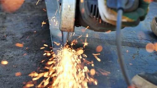 Worker Cutting Metal Sheet with Angle Grinder Creating Bright Orange Sparks in Moscow