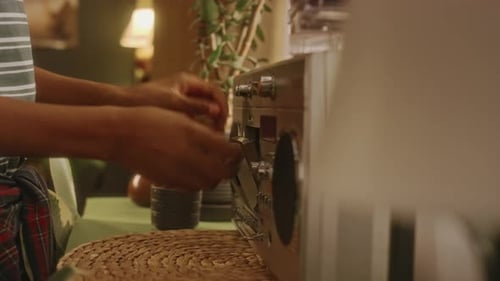 Un enfant sans visage met une cassette dans un magnétophone radio rétro à la maison